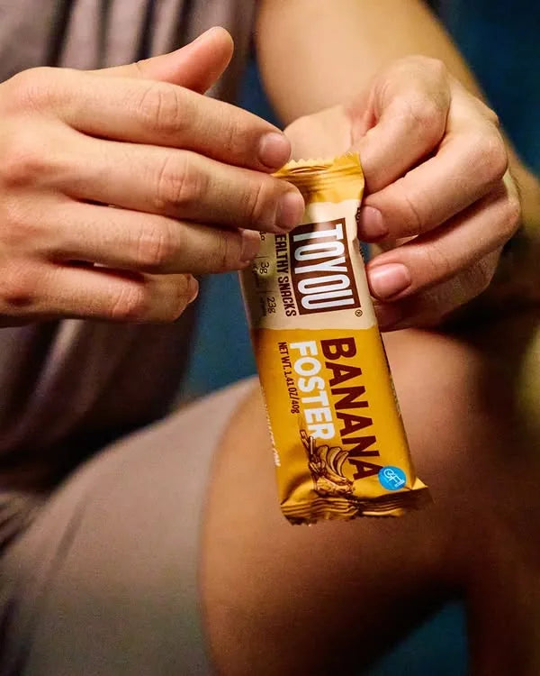 Hands opening a Banana Foster ToYou bar