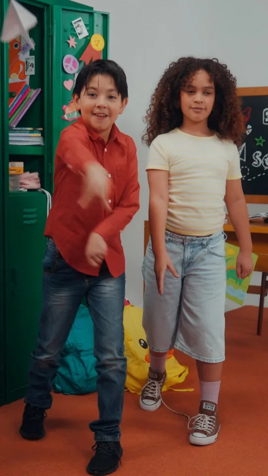 Two kids dancing in a classroom